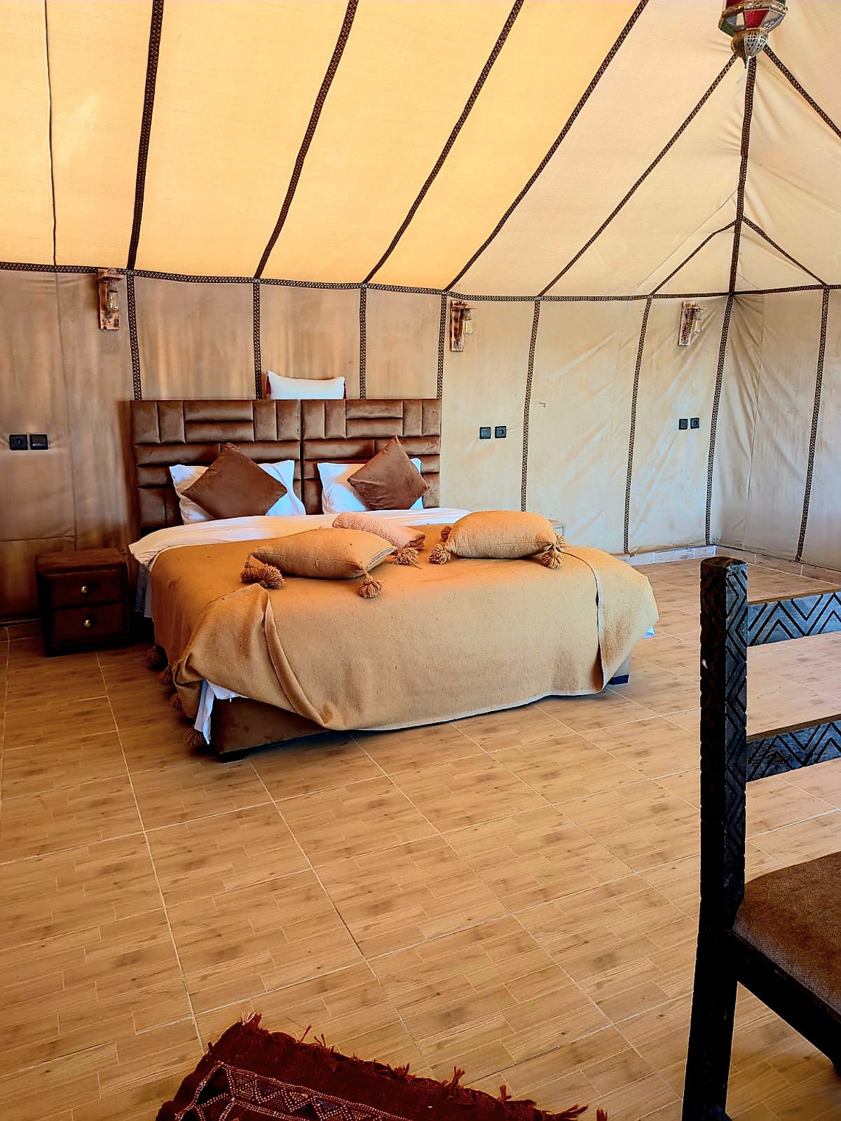 Triple tent accommodation with beds at the desert camp